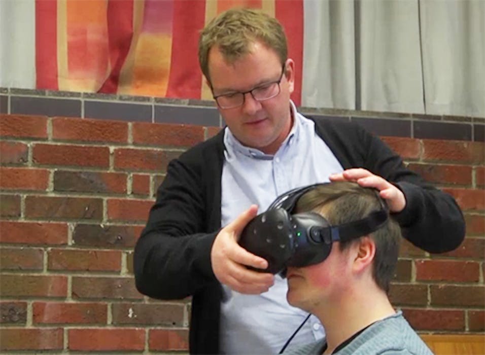 Innovasjon i praksis. Gassco-ansatte Håkon Hilmar Ferkingstad hjelper en skoleelev med VR-brillene. (Bilde: KarmøyNytt).